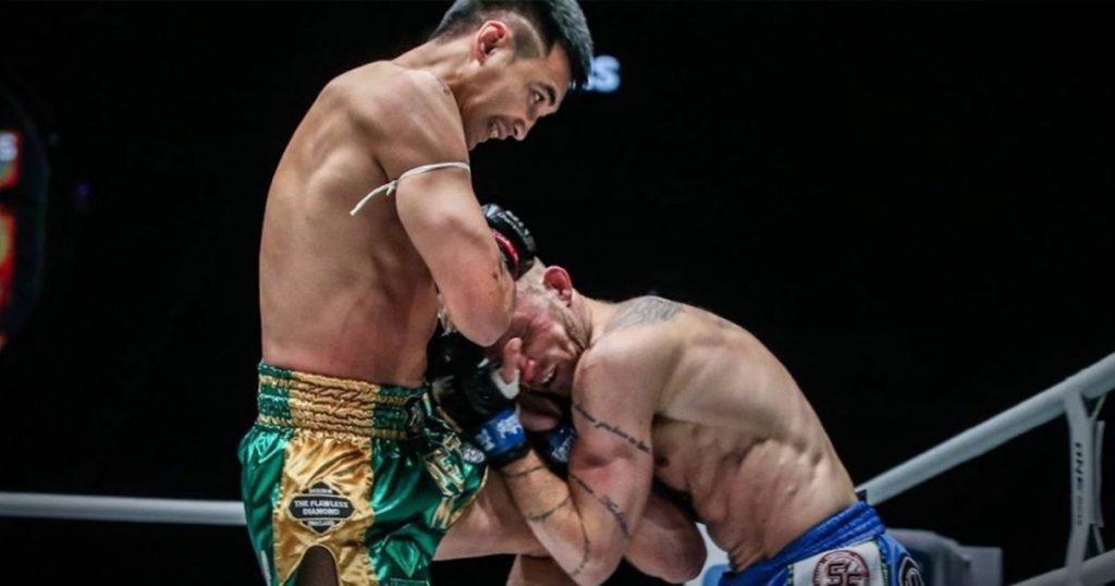 Muay Khao A Muay Thai fighter clinching an opponent and delivering a knee attack.